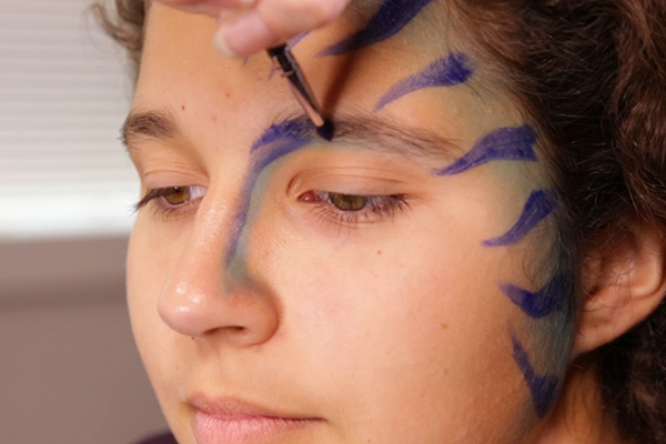 You apply the acrylic blue paint on nose, step 4 of the Avatar Face Paint Tutorial.