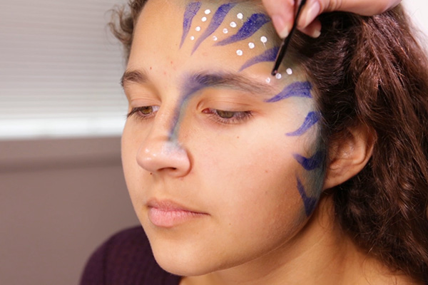 You apply the acrylic white paint for dots, step 5 of the Avatar Face Paint Tutorial.