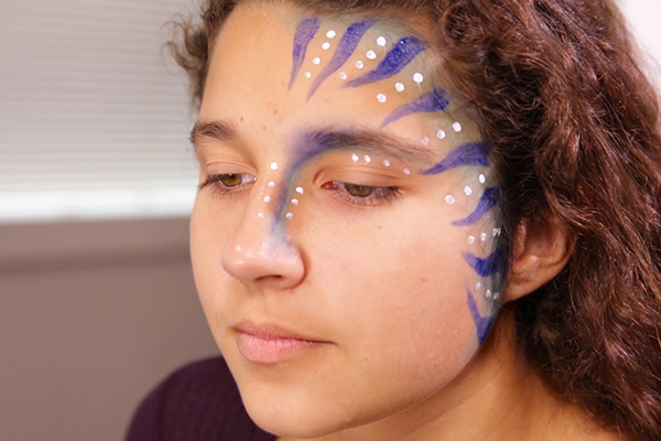 You apply more acrylic white dots, step 6 of the Avatar Face Paint Tutorial.